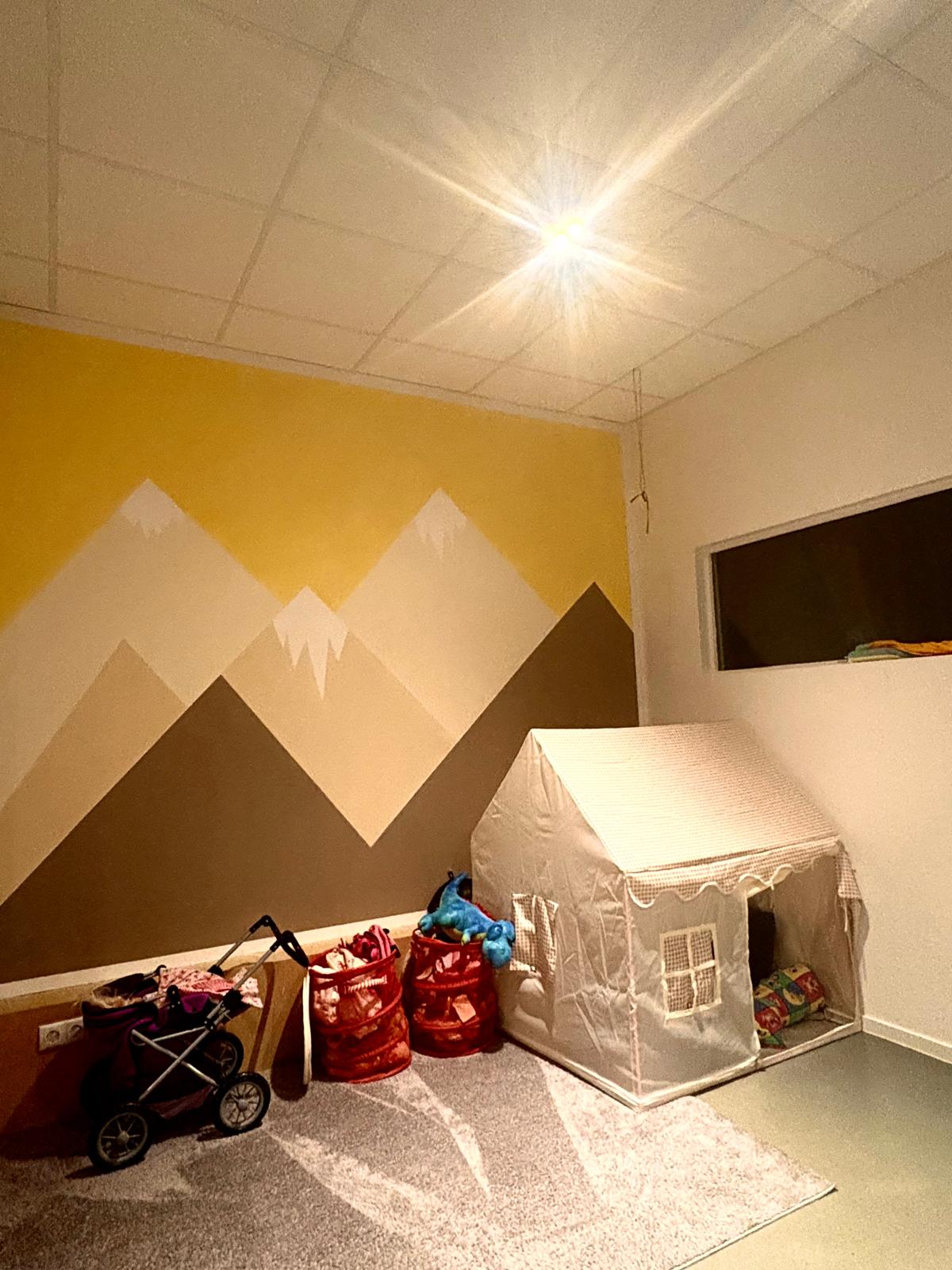 Einblick in den Raum: Spielecke und gemütlicher Bereich